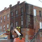 Stabilization begins at former Tasty Nut Shop building, Mesh cover placed, foundation stabilization in progress