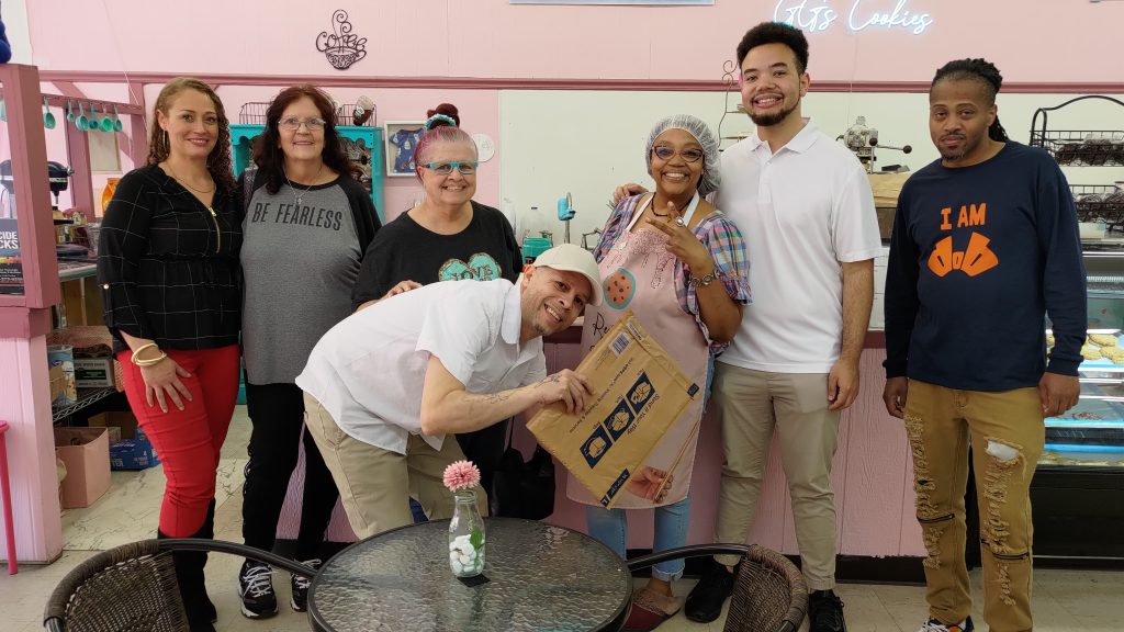 A group of seven people pose for a picture following a movie shoot at GG's Cookies in Downtown Three Rivers.